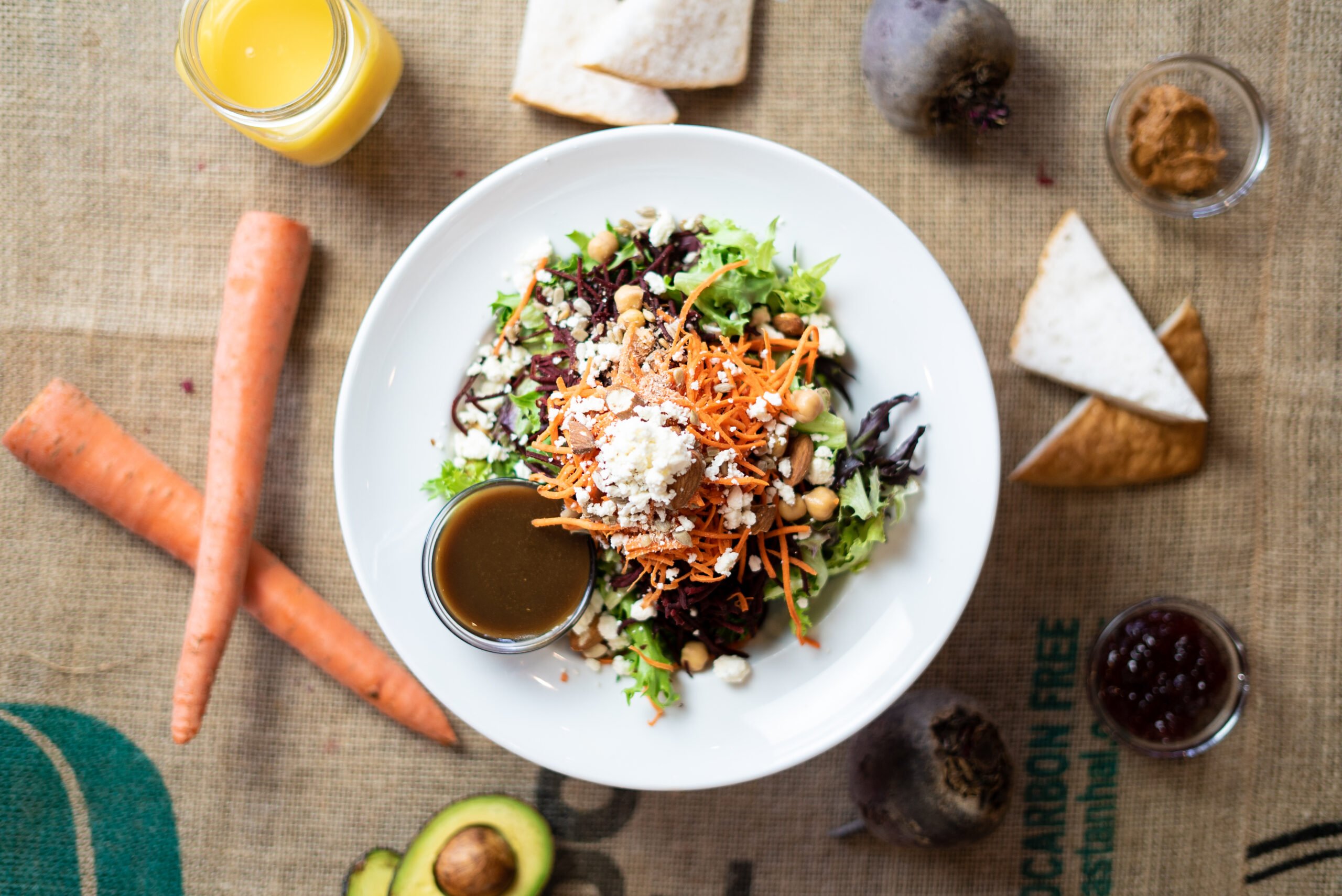 VILLAGE Salad - grated beets + carrots, chickpeas, feta, toasted almonds, sunflower seeds and artisan greens, curried balls dressing